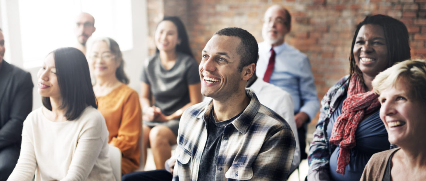 happy people listening to speaker in training session Alternative
